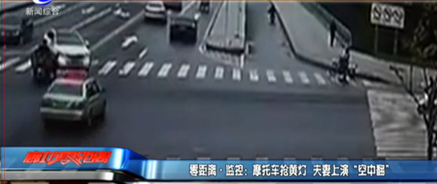 摩托車(chē)搶黃燈 夫妻上演“空中翻”