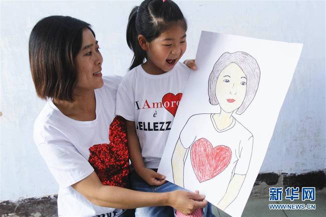 5月10日，在河北唐山市豐潤區(qū)迎賓路幼兒園開展的“媽媽，我愛你”主題活動中，陳悅寧小朋友將自己的繪畫作品送給媽媽作為節(jié)日禮物。 新華社發(fā)（朱大勇 攝）