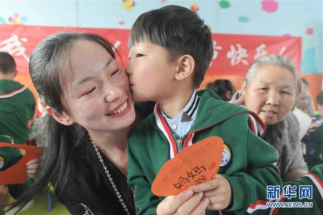 5月10日，在湖北省襄陽市一家幼兒園舉辦的母親節(jié)主題活動中，一名小朋友將自己制作的賀卡獻給媽媽。 新華社發(fā)（安富斌 攝）