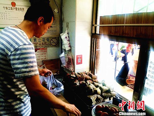 圖為凌君道正在將粽子裝袋進行售賣?！「呖档?攝