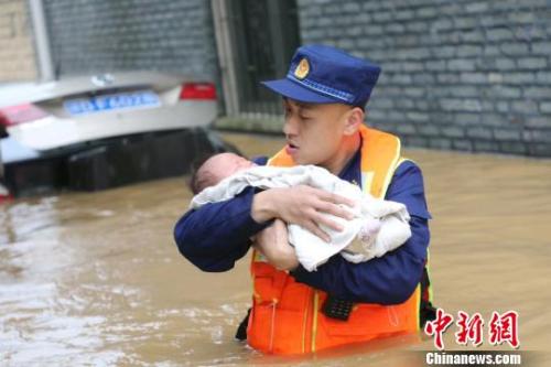 6月10日，江西省吉安縣梅塘鄉(xiāng)渡口村，消防員蹚著齊腰深的洪水，小心翼翼地將嬰兒轉(zhuǎn)移到安全地帶?！」逶?攝